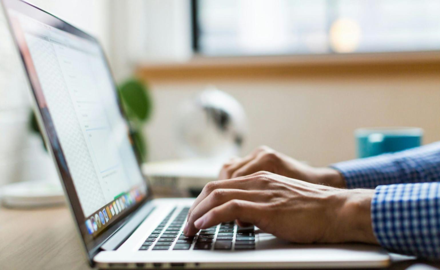 Professional financial analyst working on complex Excel model with multiple monitors